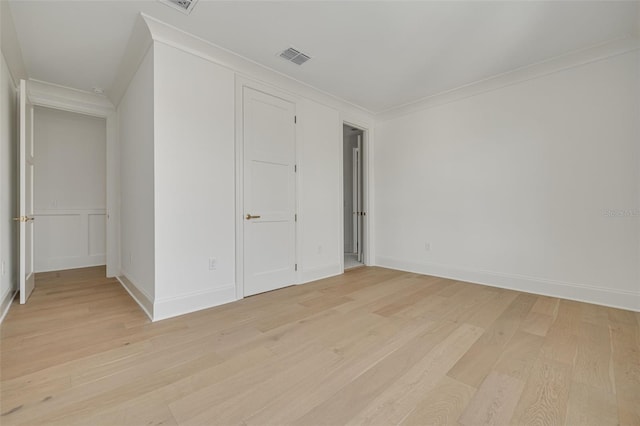 spare room featuring light hardwood / wood-style flooring and ornamental molding