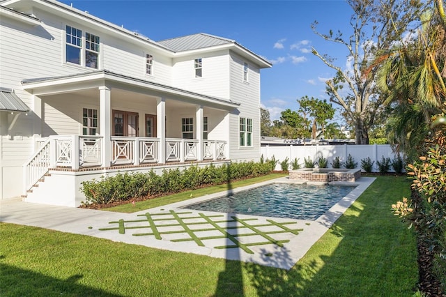 back of property with a fenced in pool, a patio area, and a yard