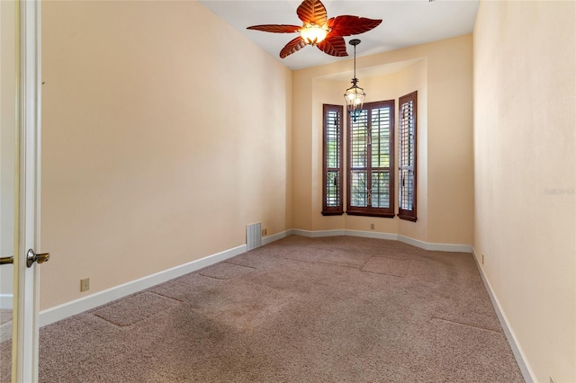 carpeted spare room with ceiling fan