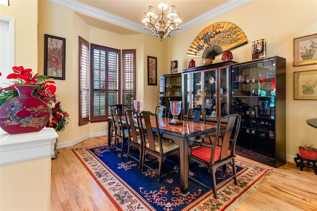 dining room with an inviting chandelier, crown molding, and hardwood / wood-style flooring