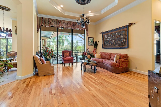 living room with a wealth of natural light, light hardwood / wood-style flooring, and a notable chandelier