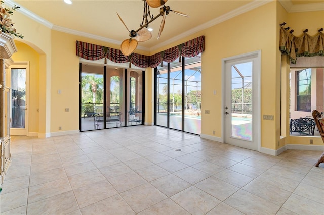 tiled spare room featuring crown molding, a notable chandelier, and a wealth of natural light