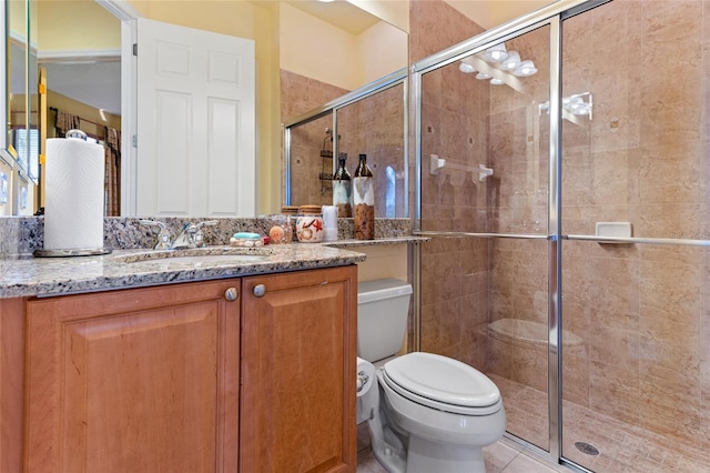 bathroom featuring vanity, a shower with shower door, toilet, and tile patterned flooring