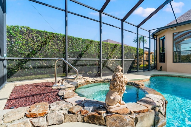 view of pool featuring an in ground hot tub, a patio area, and glass enclosure