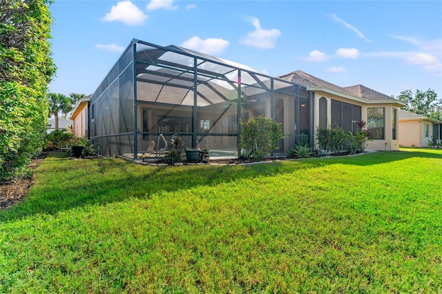 back of property with a lawn and glass enclosure