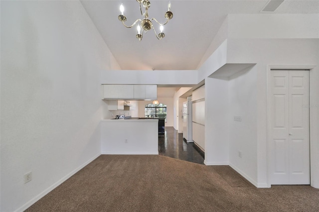 unfurnished living room with dark carpet and an inviting chandelier