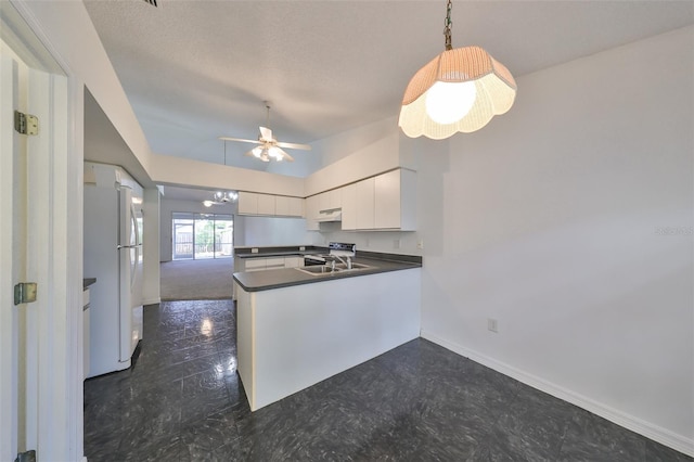 kitchen with white cabinetry, sink, ceiling fan, kitchen peninsula, and white fridge