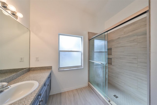 bathroom with a shower with door, vanity, and hardwood / wood-style floors