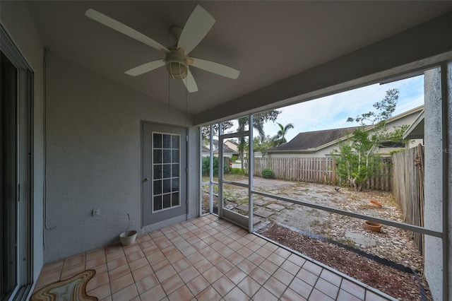 unfurnished sunroom featuring ceiling fan