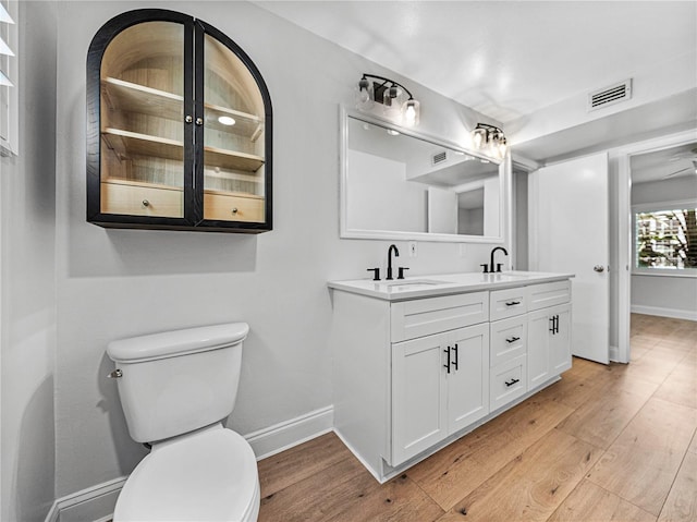 bathroom featuring vanity, hardwood / wood-style flooring, and toilet