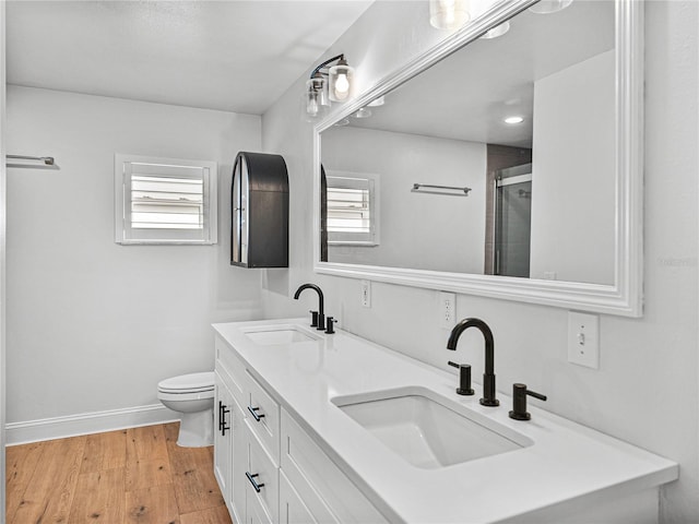 bathroom featuring toilet, plenty of natural light, a shower with door, and hardwood / wood-style flooring