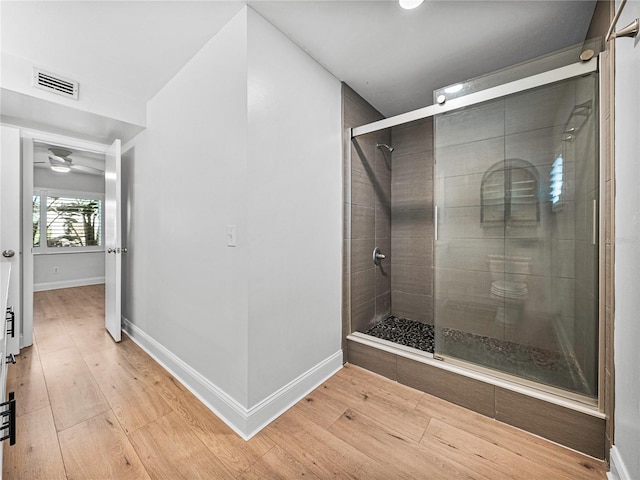 bathroom with hardwood / wood-style flooring and a shower with door