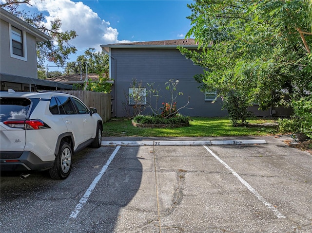 view of parking with a lawn