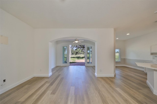 unfurnished living room with light hardwood / wood-style flooring and ceiling fan