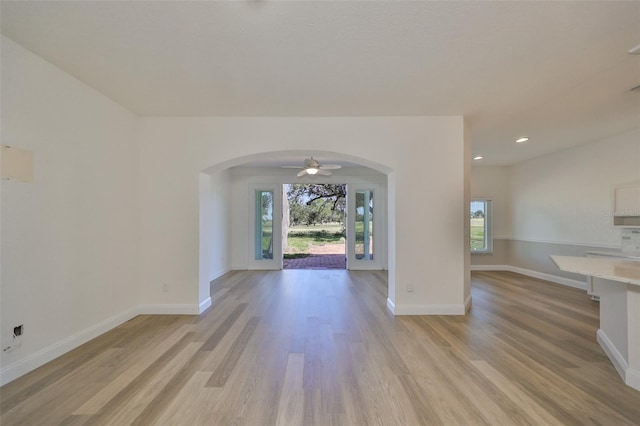 1148 Emerald Hill Way, Valrico, FL 33594 - unfurnished living room with arched walkways, light wood-style floors, baseboards, recessed lighting, and a ceiling fan