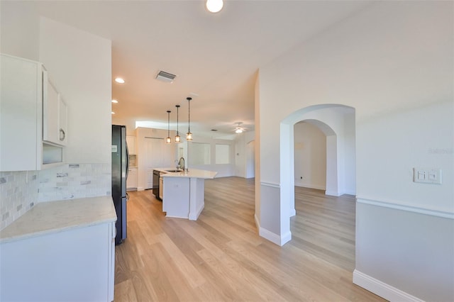 1148 Emerald Hill Way, Valrico, FL 33594 - kitchen featuring a sink, decorative backsplash, ceiling fan, arched walkways, and white cabinetry