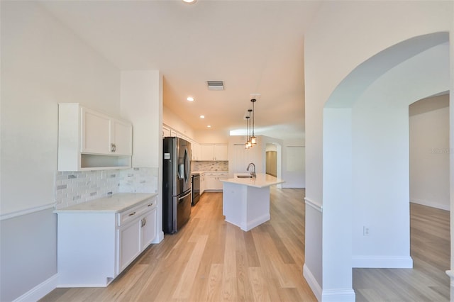 kitchen with white cabinets, hanging light fixtures, a kitchen island with sink, sink, and stainless steel appliances