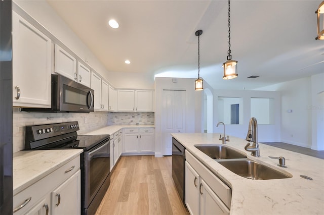 kitchen with hanging light fixtures, sink, black appliances, light wood-type flooring, and white cabinetry