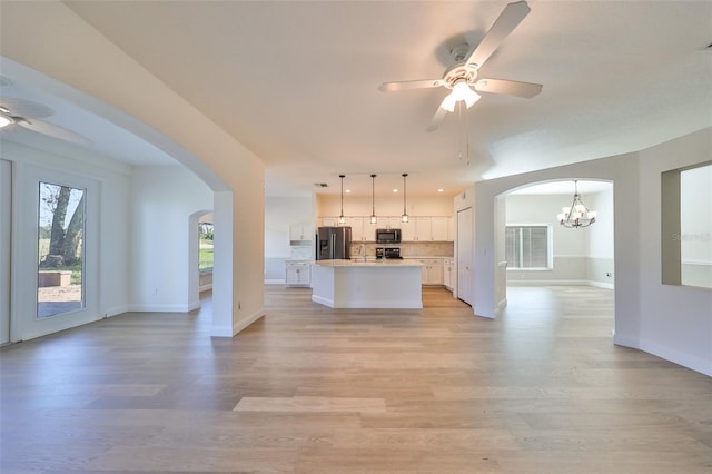 1148 Emerald Hill Way, Valrico, FL 33594 - kitchen featuring appliances with stainless steel finishes, open floor plan, ceiling fan, arched walkways, and white cabinetry