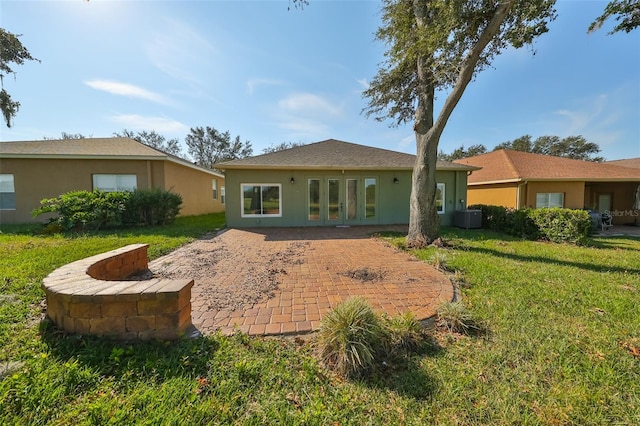 rear view of property featuring french doors, a yard, central air condition unit, and a patio