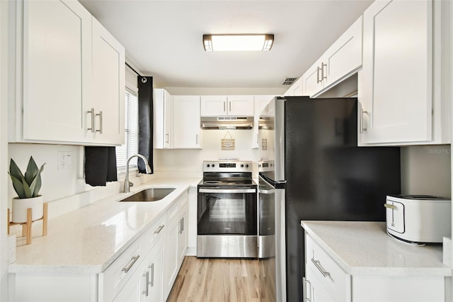 kitchen with sink, stainless steel appliances, white cabinets, light stone counters, and light hardwood / wood-style flooring