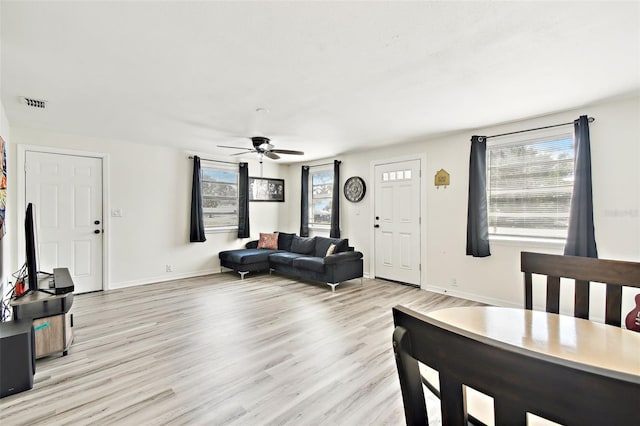 living room with light hardwood / wood-style floors and ceiling fan