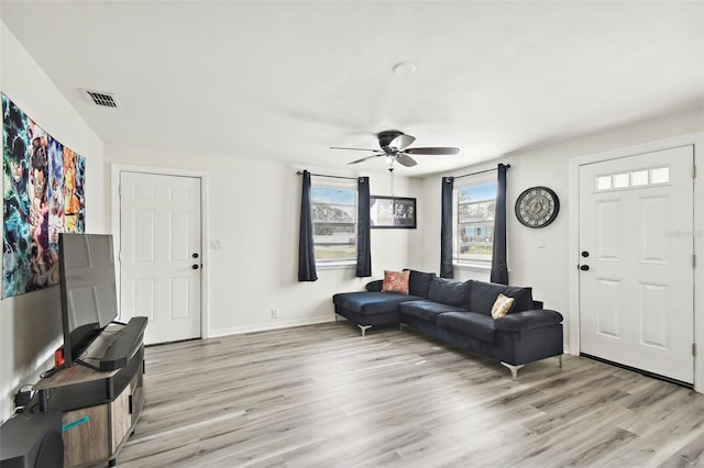 living room featuring light hardwood / wood-style flooring and ceiling fan