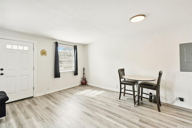 dining room with electric panel and light wood-type flooring