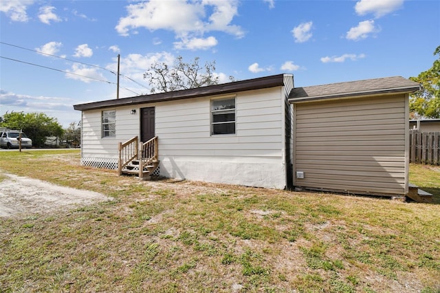 rear view of property featuring a yard