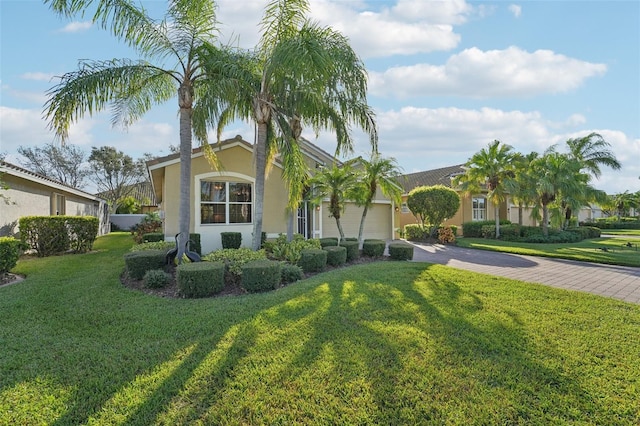 ranch-style home with a garage and a front lawn