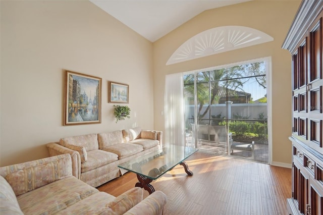 living room featuring vaulted ceiling and light hardwood / wood-style floors