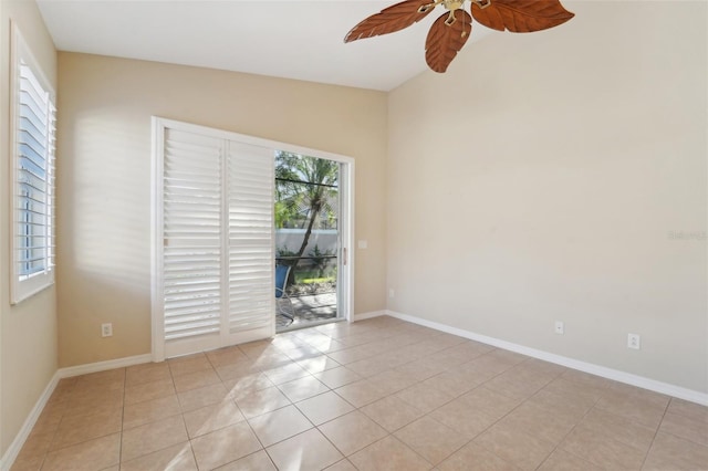 tiled spare room featuring vaulted ceiling and ceiling fan