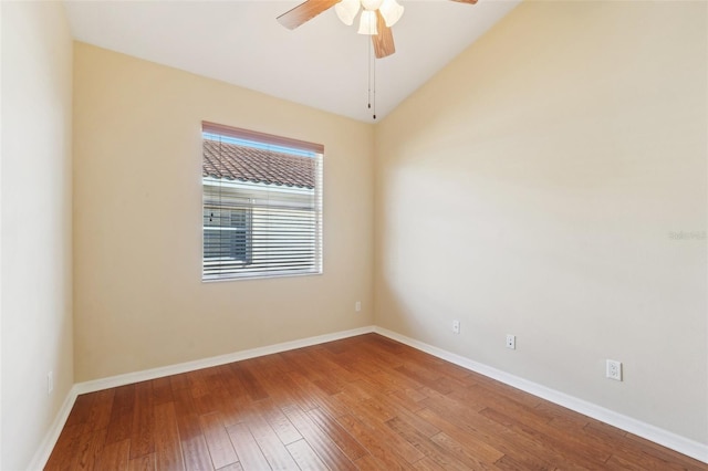 empty room with vaulted ceiling, hardwood / wood-style flooring, and ceiling fan