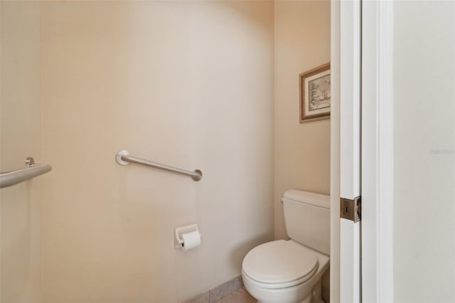 bathroom with toilet and tile patterned flooring