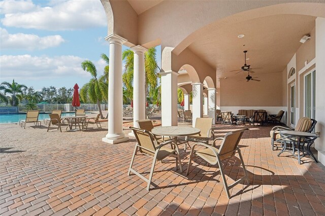 view of patio featuring a community pool and ceiling fan