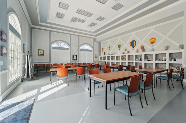 dining area with a tray ceiling and concrete flooring