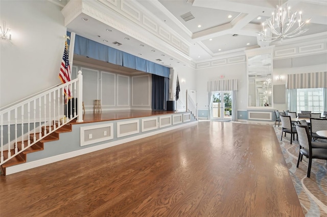 living room with hardwood / wood-style floors, beamed ceiling, coffered ceiling, and a high ceiling