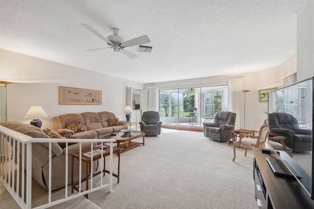 carpeted living room featuring a textured ceiling and ceiling fan