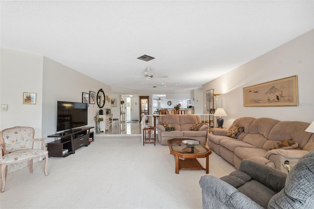 carpeted living room with ceiling fan