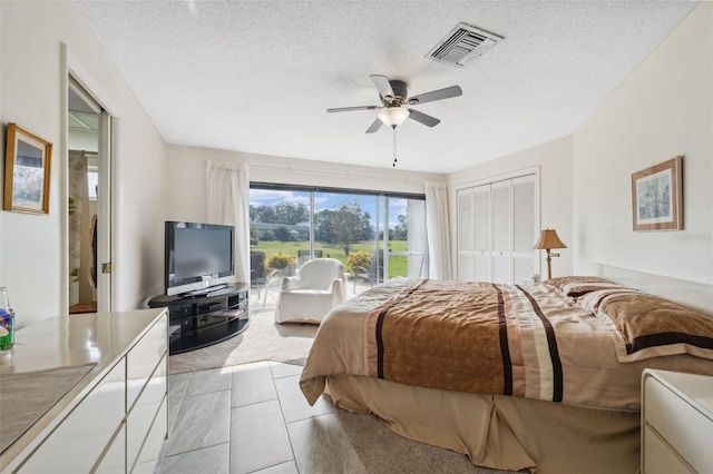 carpeted bedroom featuring ceiling fan, a textured ceiling, and a closet