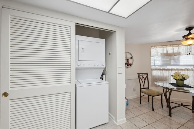 clothes washing area featuring stacked washer / drying machine and light tile patterned flooring