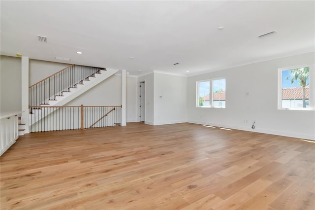 unfurnished living room with crown molding, stairs, visible vents, and light wood-style flooring