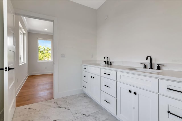 full bathroom featuring a sink, baseboards, double vanity, and marble finish floor