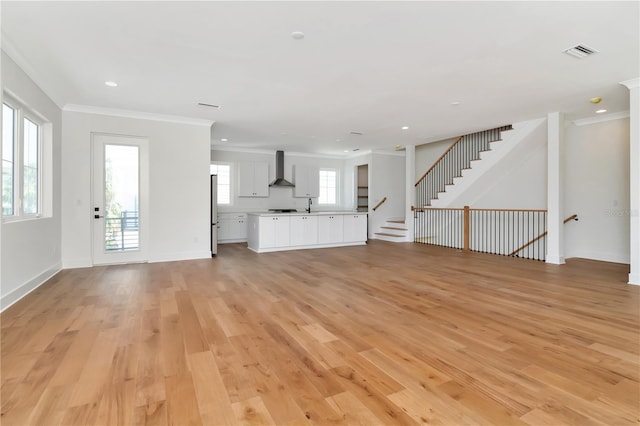 unfurnished living room with visible vents, ornamental molding, light wood finished floors, and recessed lighting