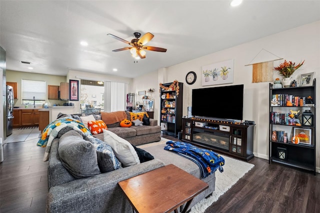 living room featuring ceiling fan and dark hardwood / wood-style flooring