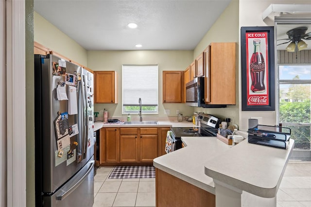 kitchen featuring kitchen peninsula, stainless steel appliances, light tile patterned flooring, and sink