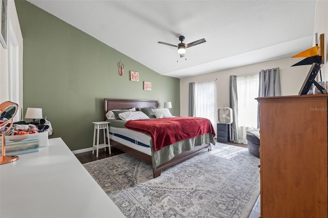 bedroom featuring hardwood / wood-style floors, vaulted ceiling, and ceiling fan