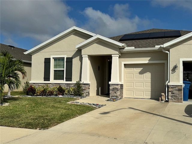 view of front facade with solar panels, a front lawn, and a garage