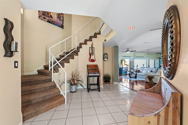 staircase with ceiling fan and tile patterned flooring