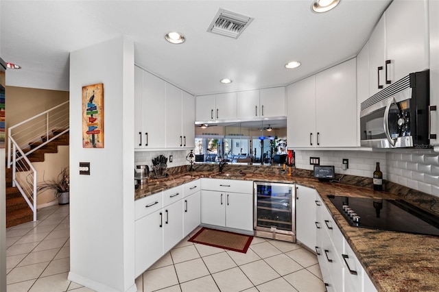 kitchen with white cabinets, decorative backsplash, and wine cooler